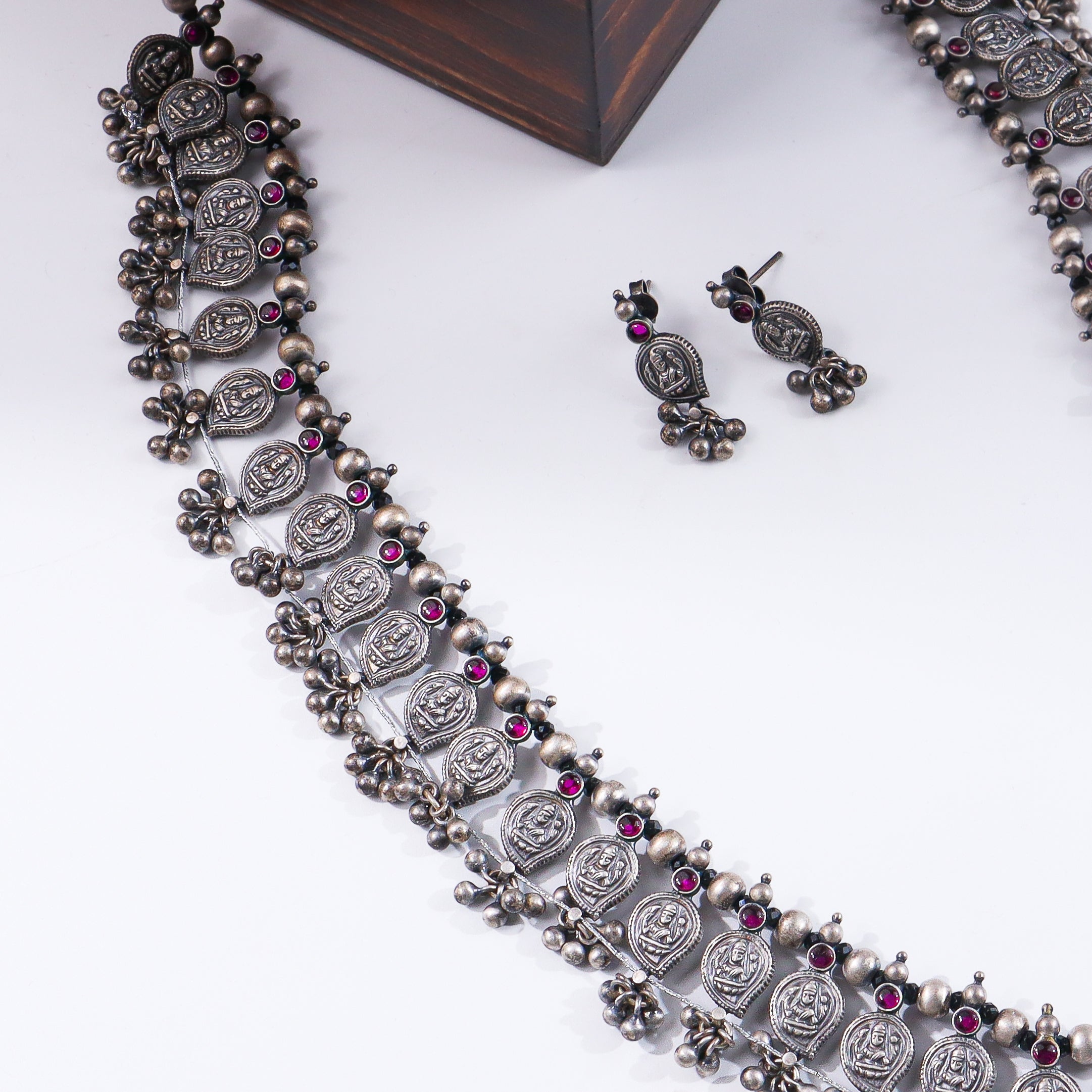 Silver oxidized necklace with traditional coin motifs and pink gemstones
