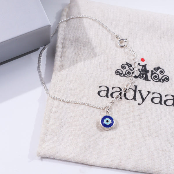 Silver Evil Eye Chain Bracelet on beige fabric