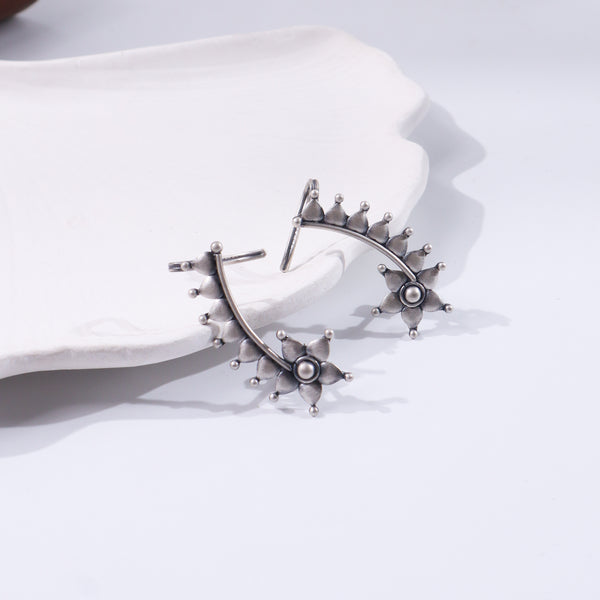 Silver floral jewelry piece on white background