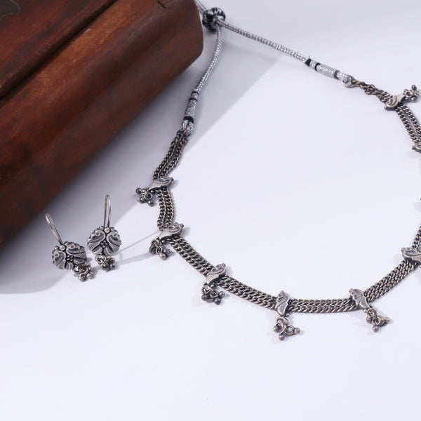 Silver jewelry set with intricate peacock motifs