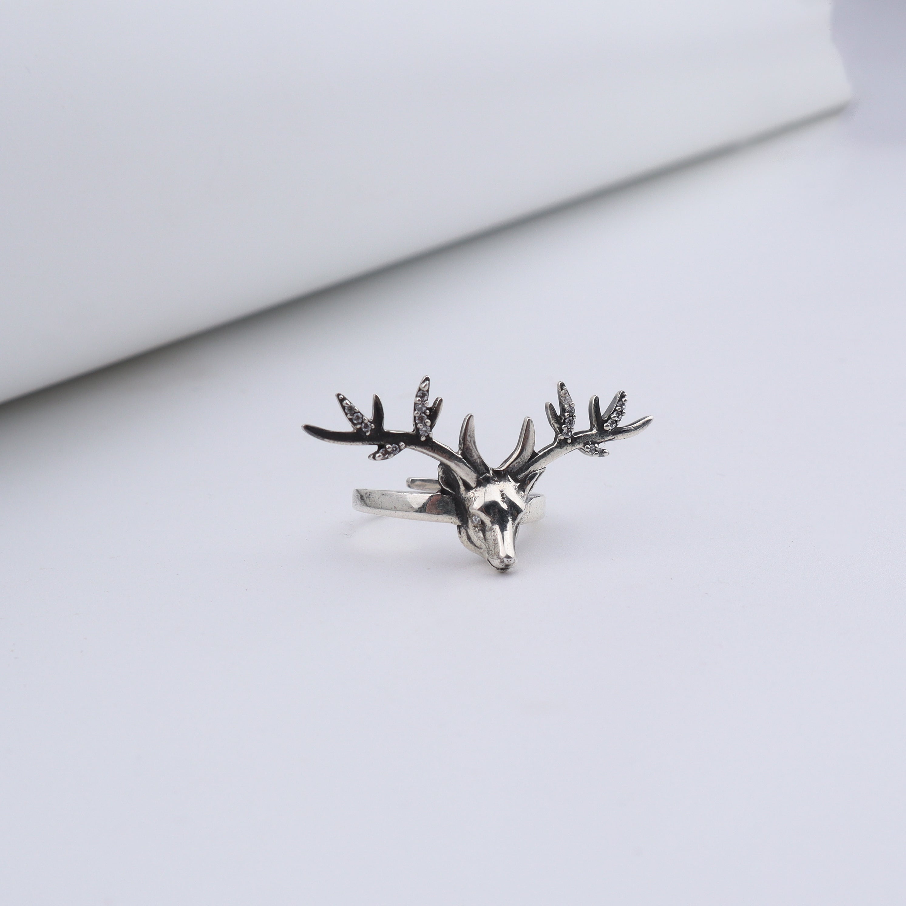 Silver deer ring with detailed antlers and gemstone accents