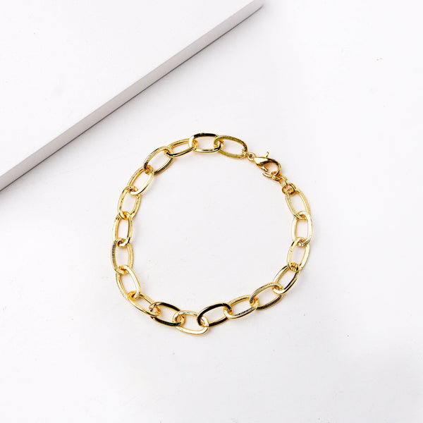 Angled view of a 22K gold-plated fashion bracelet highlighting its elegant structure, unique design, and polished gold finish