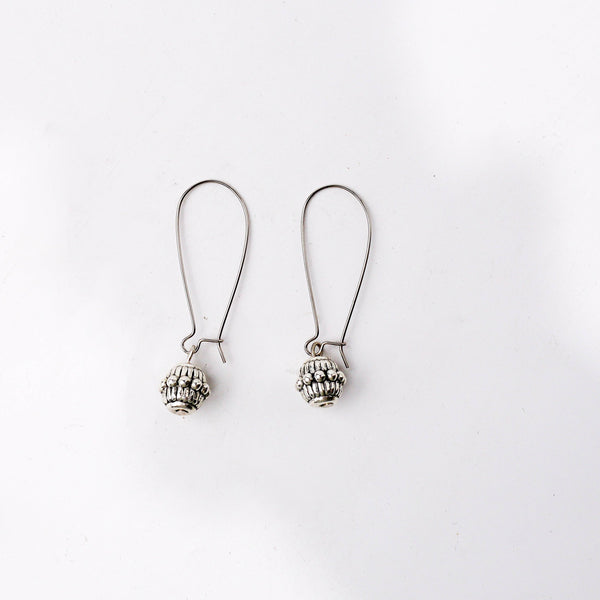 Detailed view of the fashion earring highlighting intricate motifs, textured detailing, and smooth jewelry finish