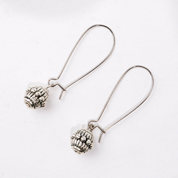 Angled view of the fashion earring highlighting its unique silhouette, structure, and polished finish