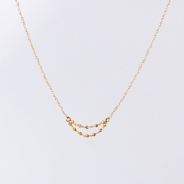 Angled view of a 22K gold-plated fashion necklace highlighting its elegant structure, unique design, and polished gold finish