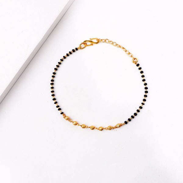 Detailed view of 22K gold-plated fashion mangalsutra bracelet highlighting traditional motifs, black bead detailing, and premium 22K gold plating
