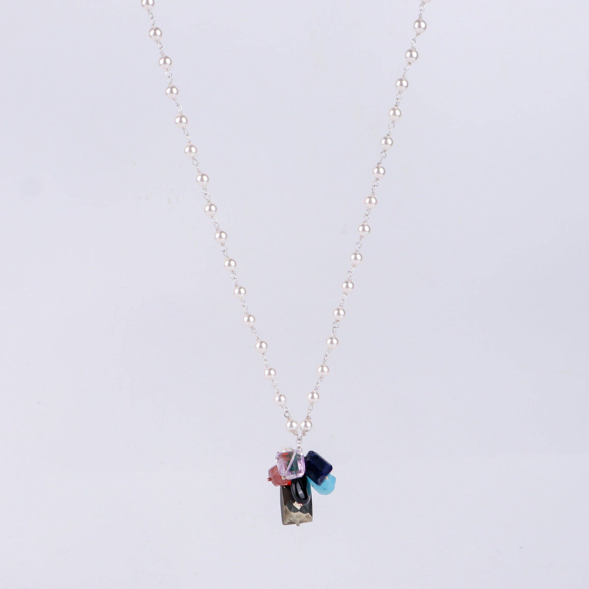 Angled side view of multicolour gemstone necklace showing layered design and silver craftsmanship