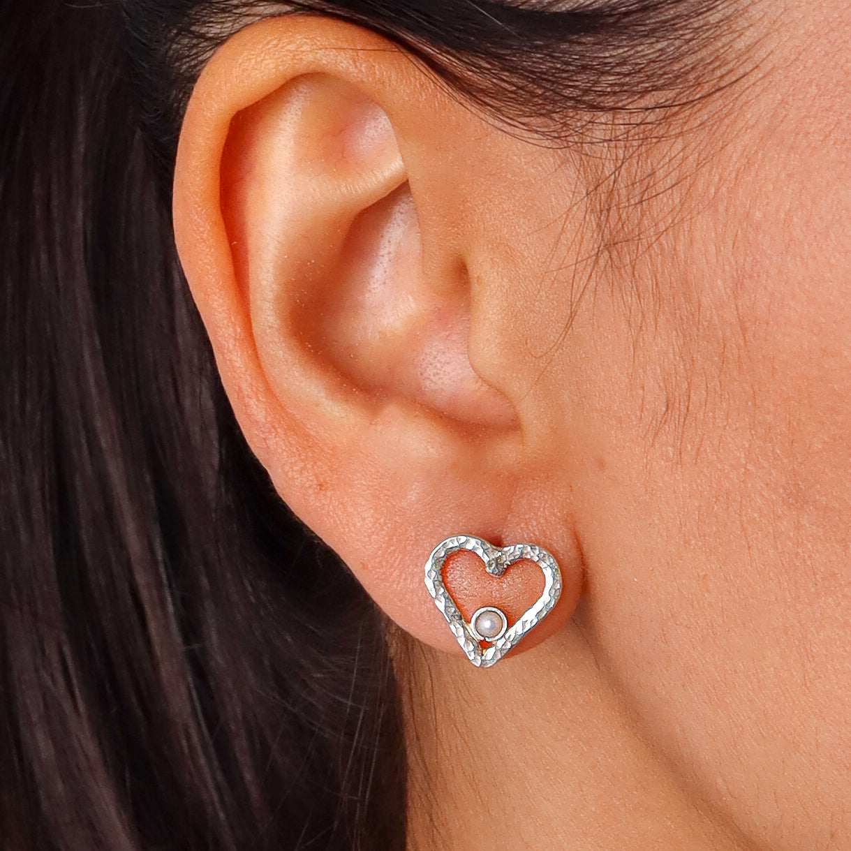 Earring worn on woman's ear with pearl detail