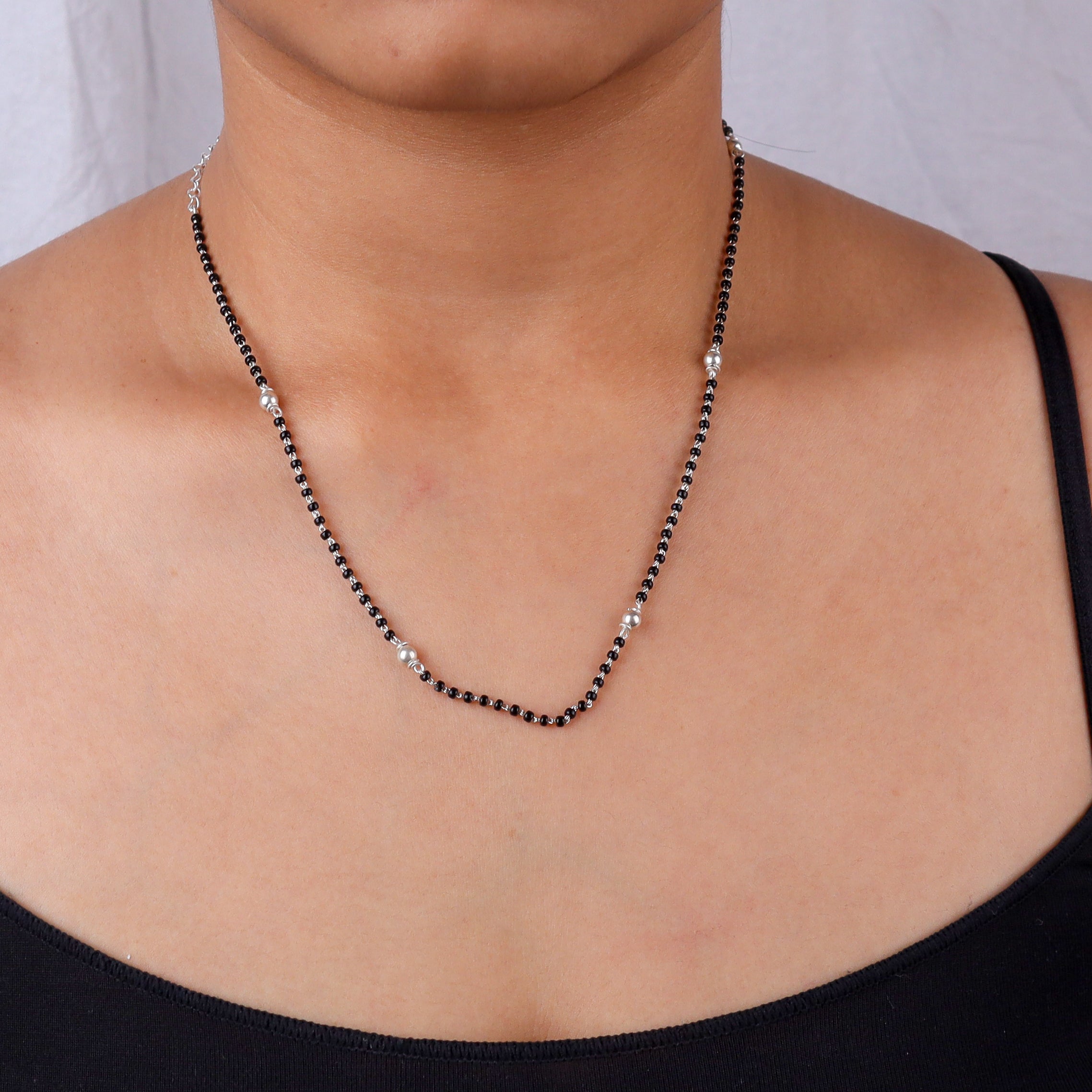 Close-up of black and silver beaded necklace on skin