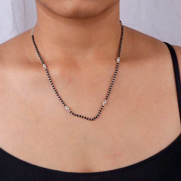 Close-up of black and silver beaded necklace on skin