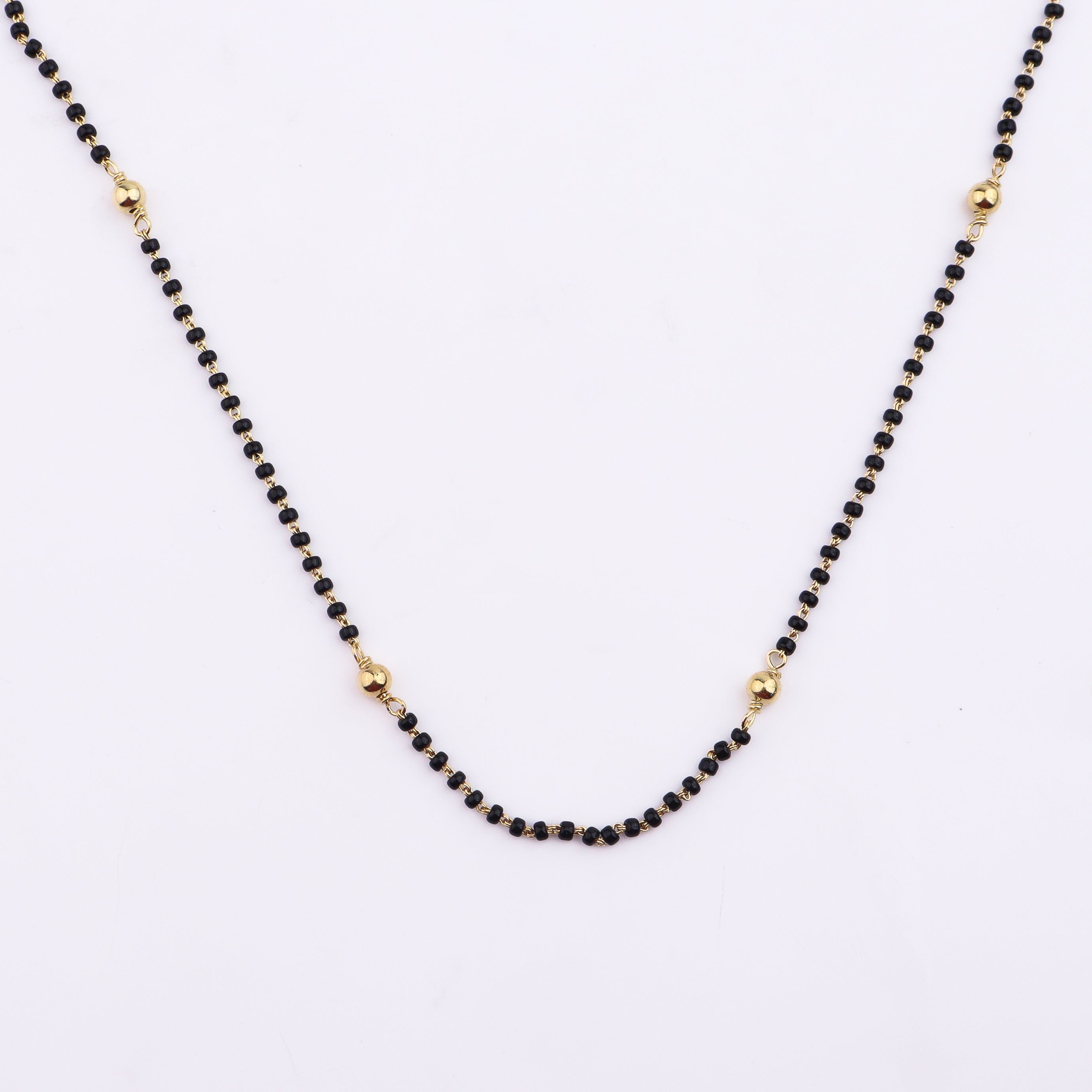 Gold Chain with Black Beads on White Background
