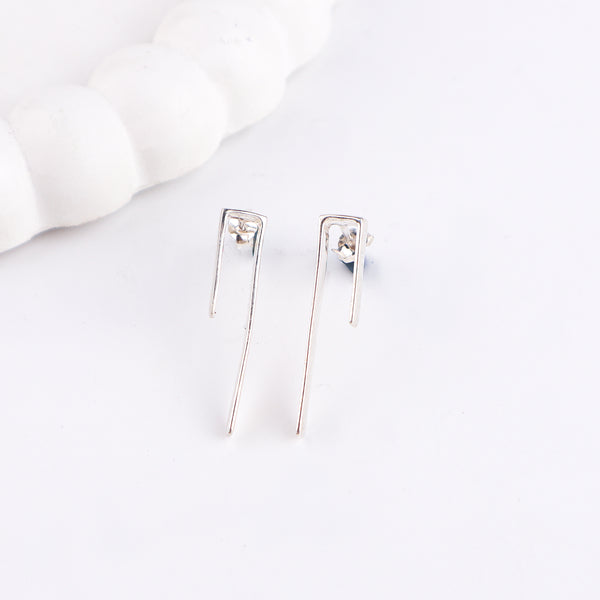 Close-up of silver minimalist earrings on white background