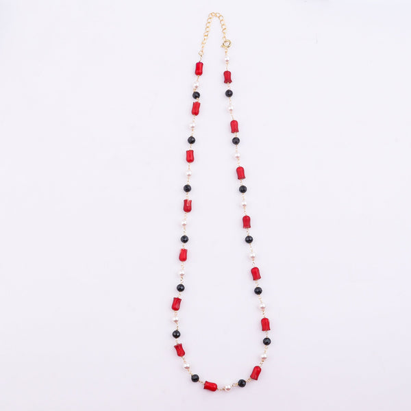 Beaded necklace with coral, pearl, and black spinel on white background
