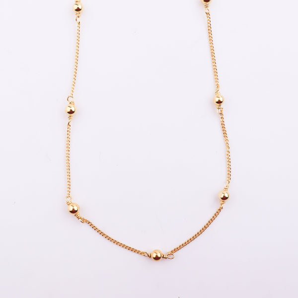 Close-up of gold chain with beads