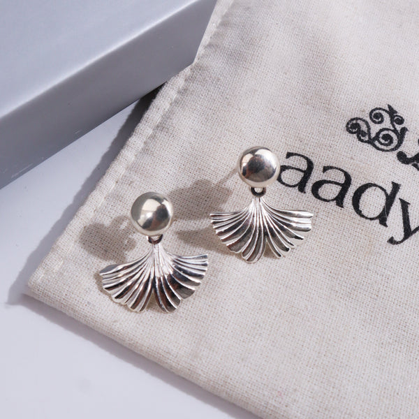 Silver earrings with ginkgo leaf design on jewelry display