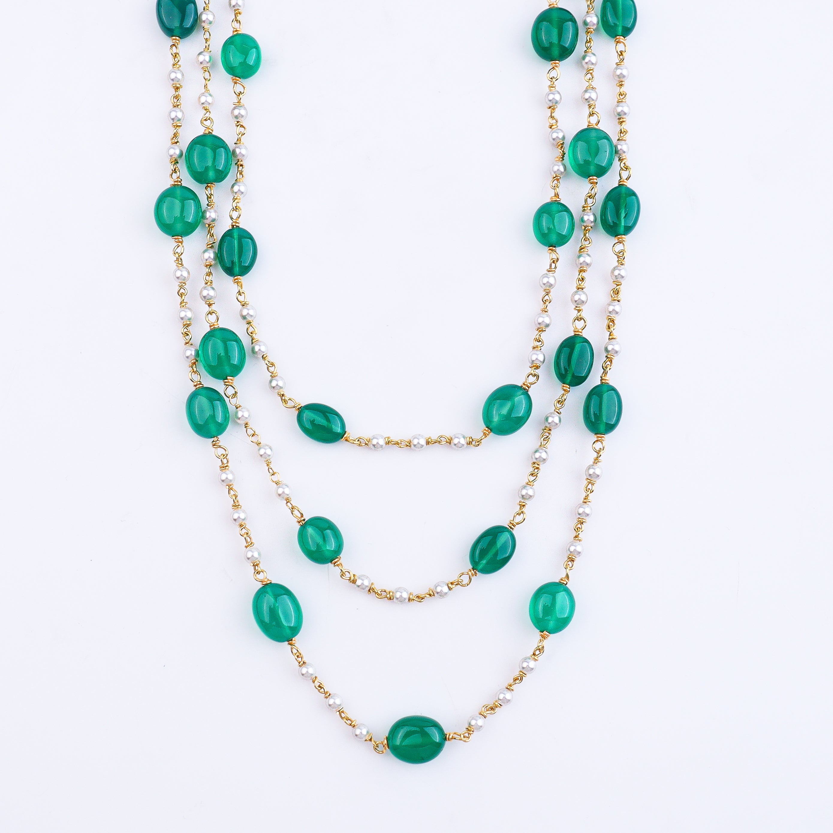 Close-up of green onyx and Swarovski pearl necklace on model