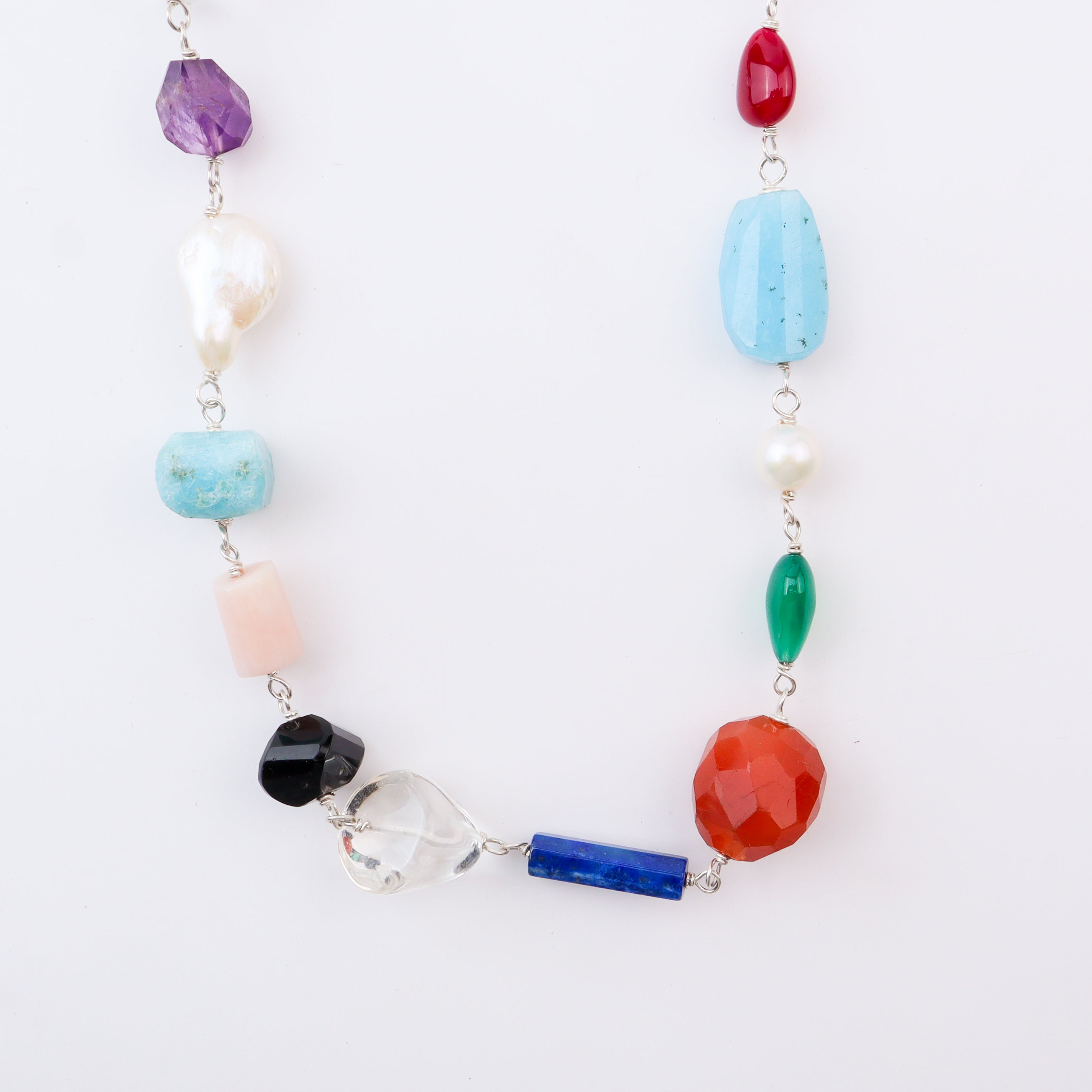 Close-up of multicolour stone necklace on white background