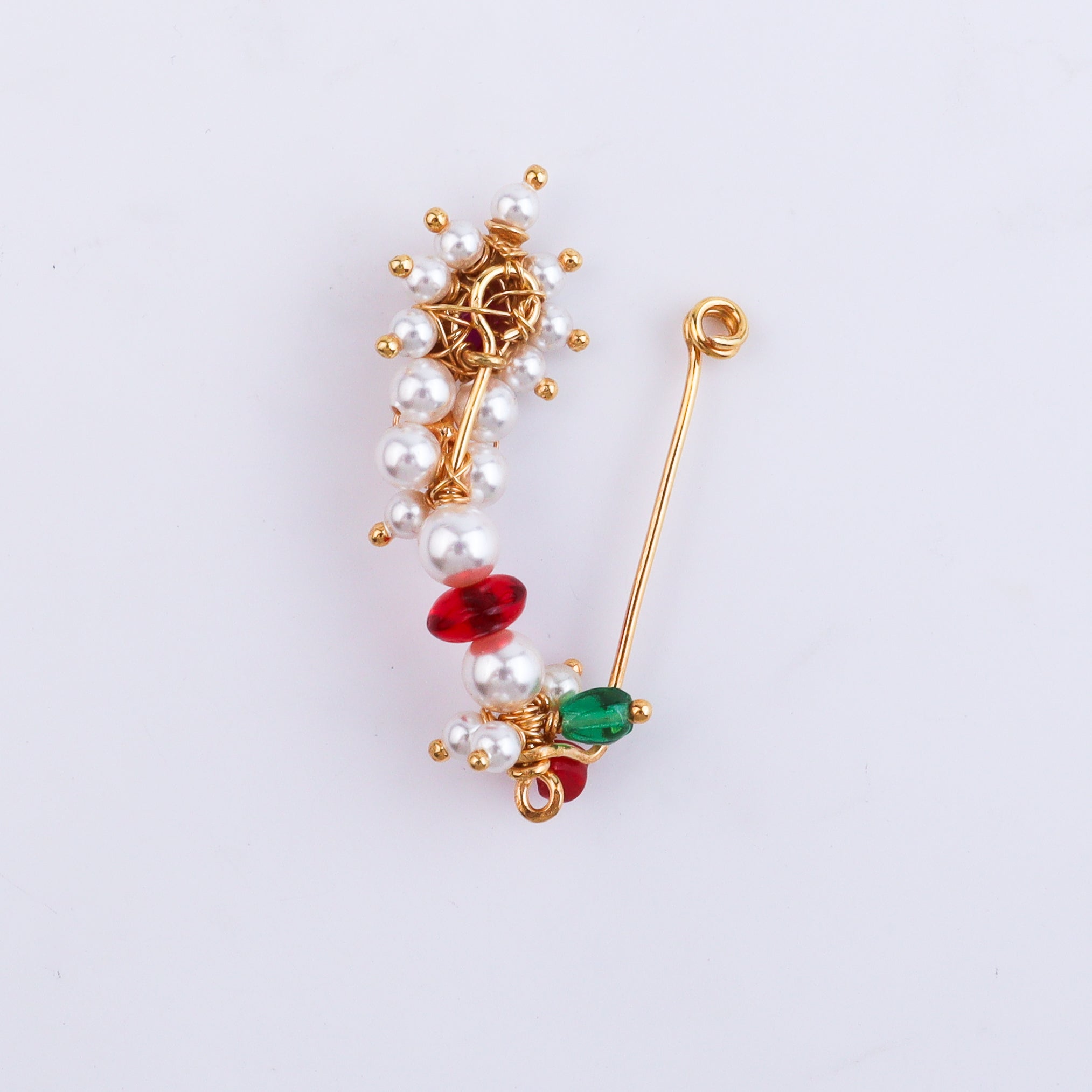 Close-up of pearl and red gemstone nose ring with gold wire detail