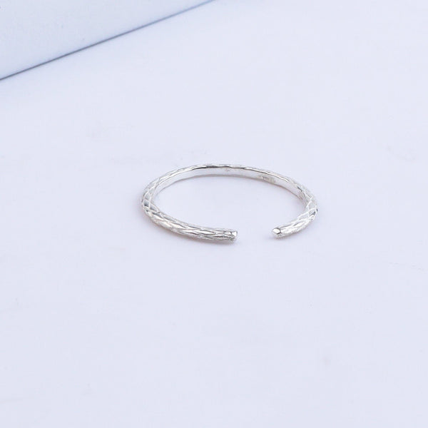 Silver textured ring on white background