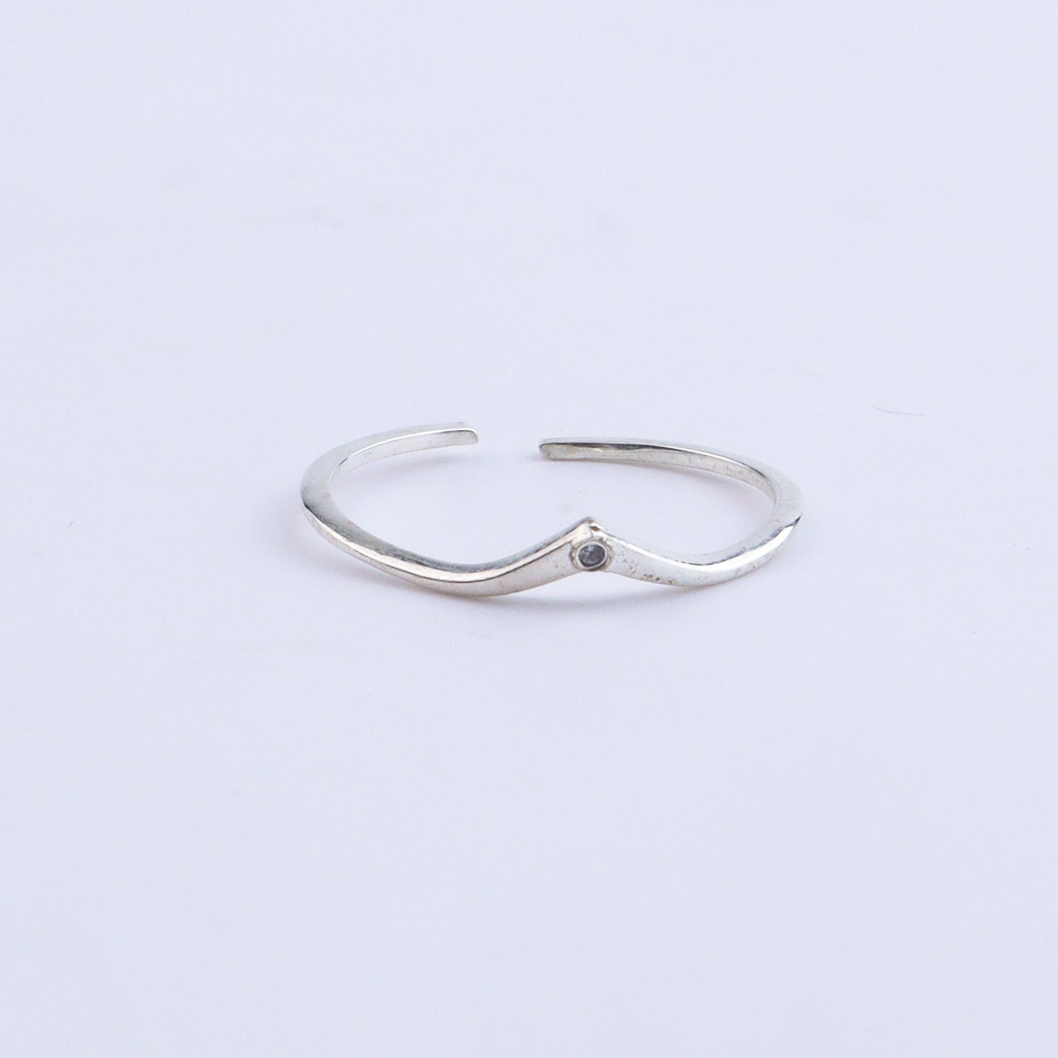 Silver open band ring on white background