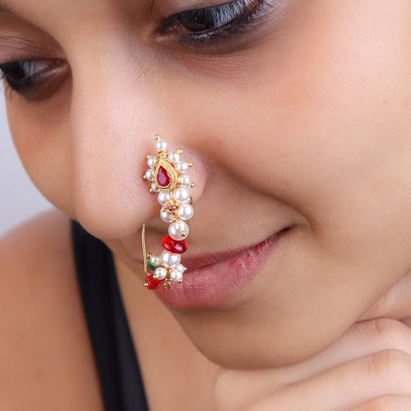 Close-up of woman wearing pearl and red gemstone nose ring