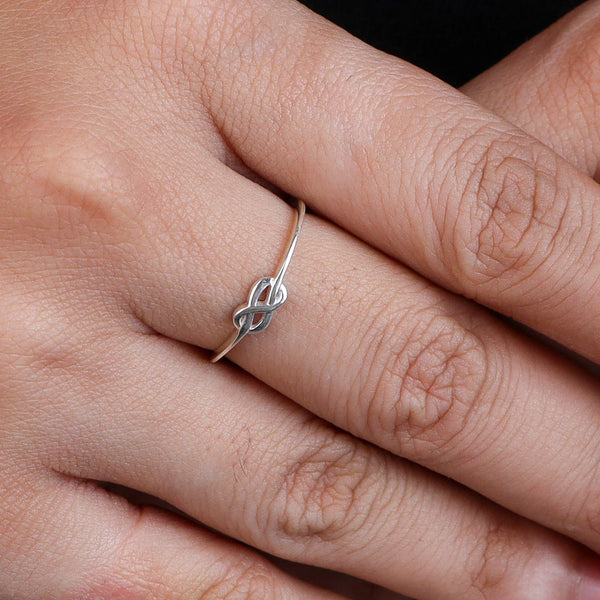 Silver infinity ring on finger