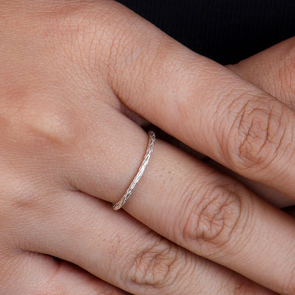 Silver textured ring worn on finger