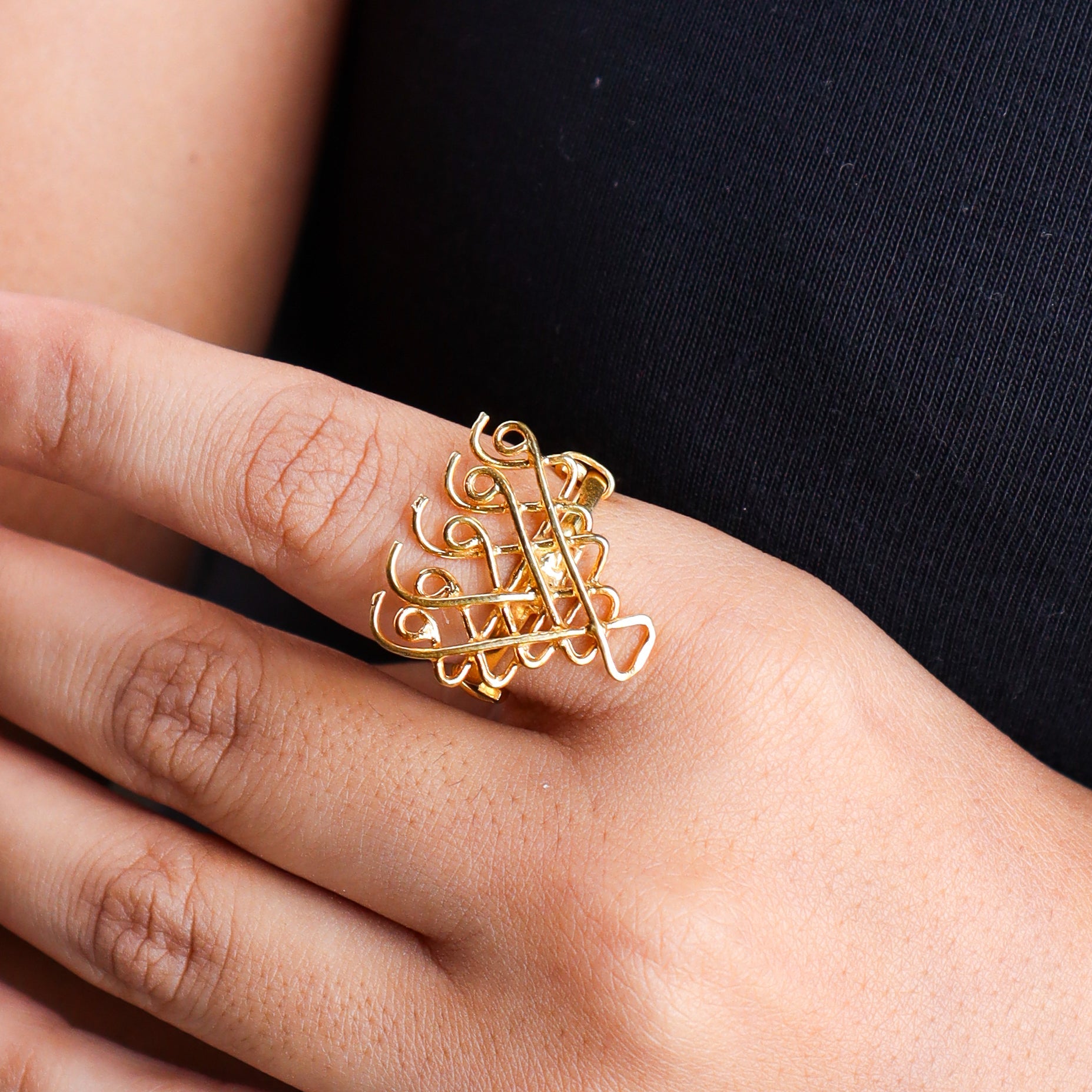 Close-up of gold plated Saraswati ring on finger