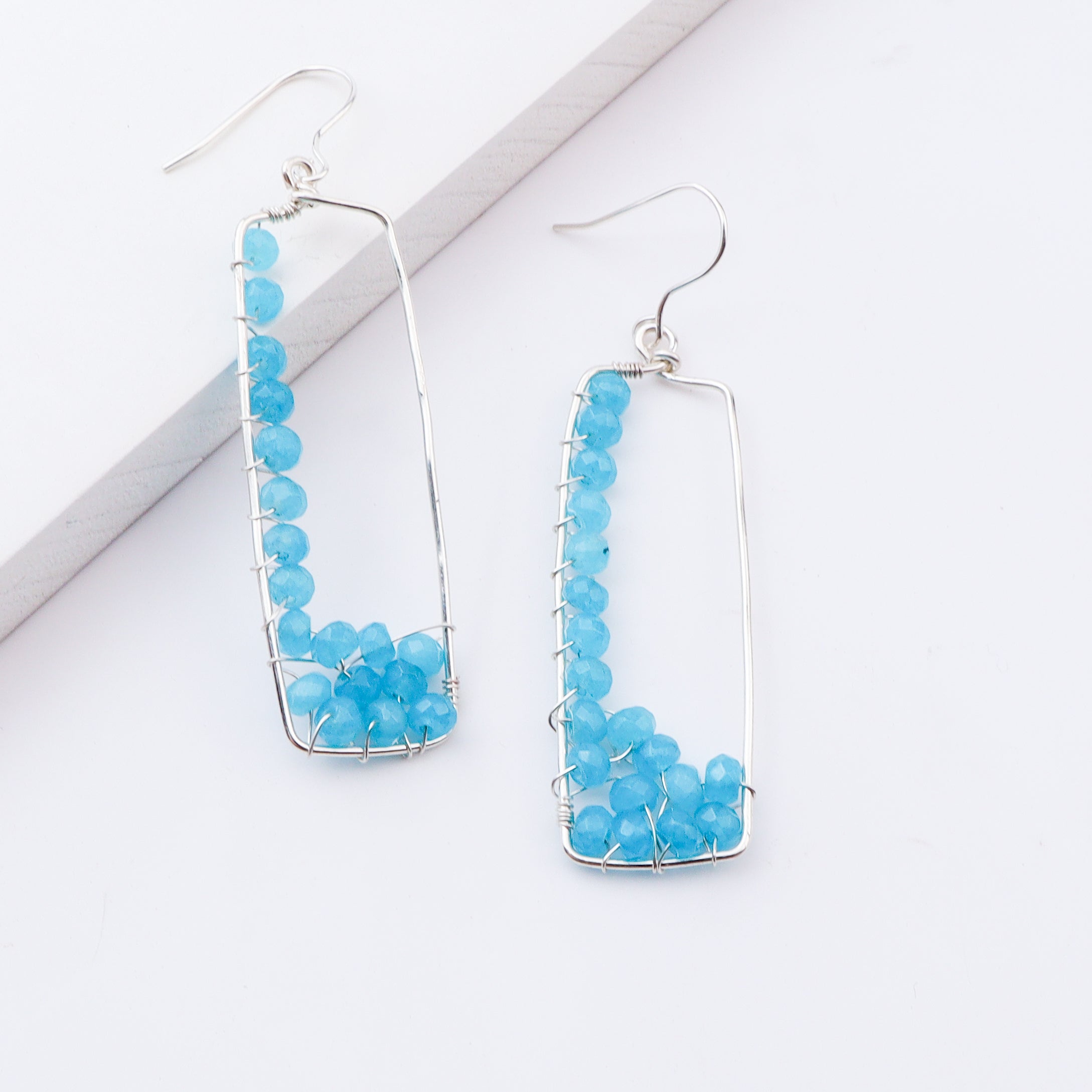 Close-up of blue bead earrings with sterling silver frame