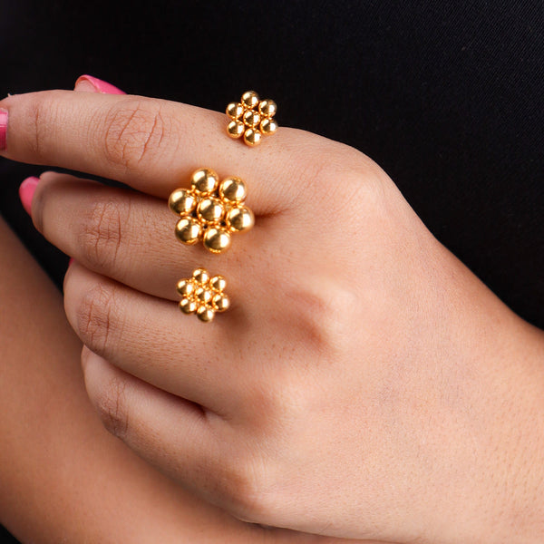 Close-up of gold plated floral cluster ring on finger