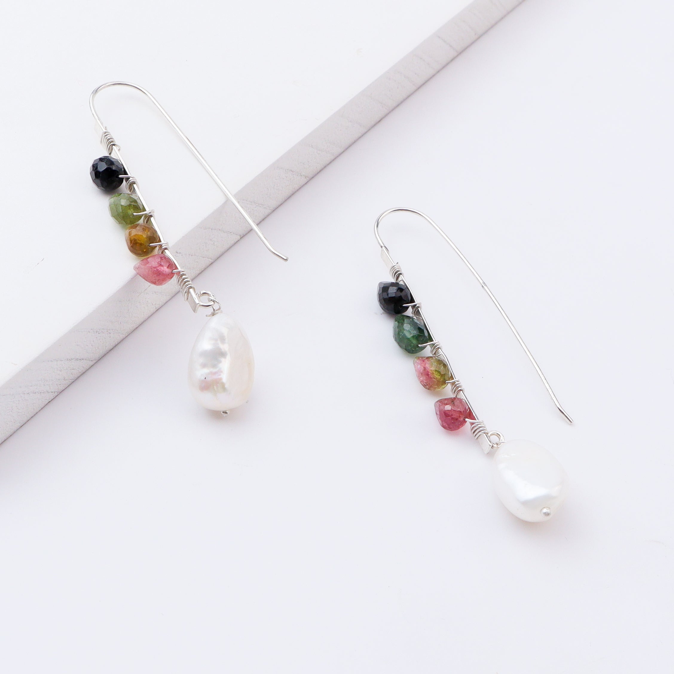 Silver multicolour stone earrings with pearl drop on white background