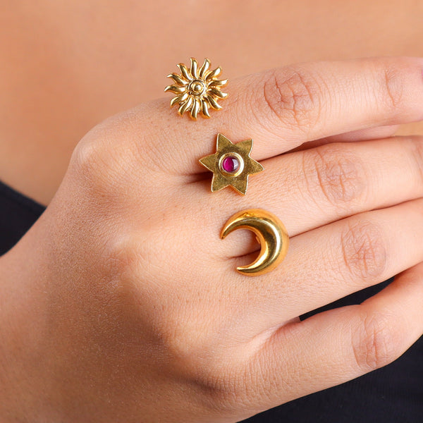 Close-up of gold moon and star rings on finger