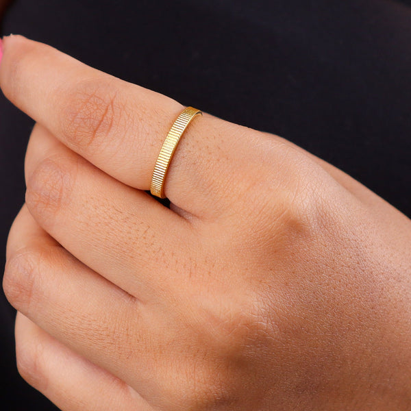 Close-up of gold textured open cuff bracelet on white background