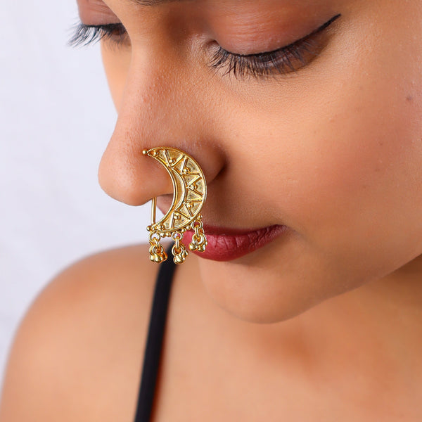 Close-up of woman's face with gold crescent moon earring