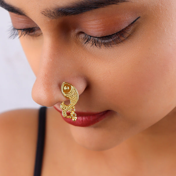 Close-up of gold nose ring on model's nose with eye makeup