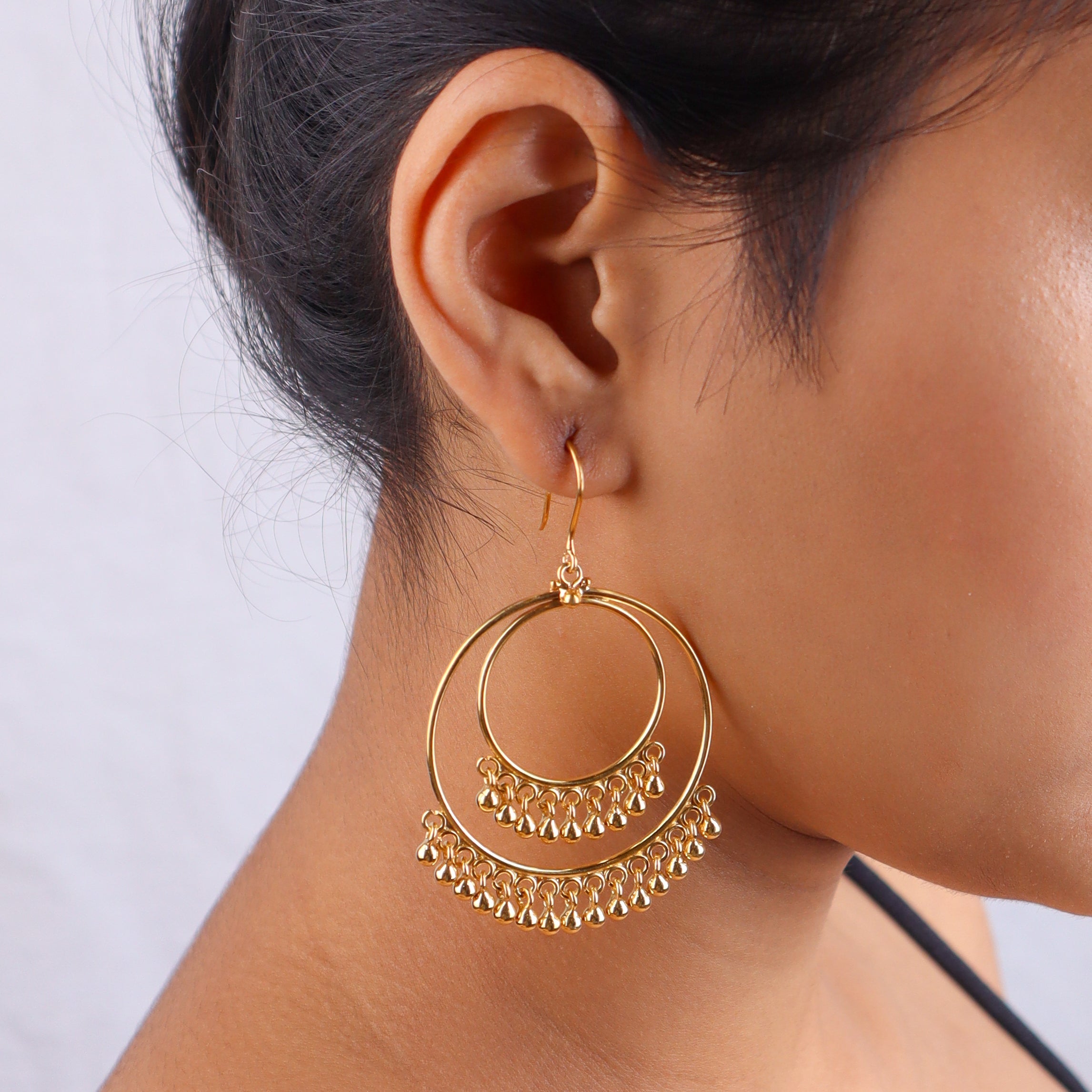 Close-up of gold earrings on model's ear