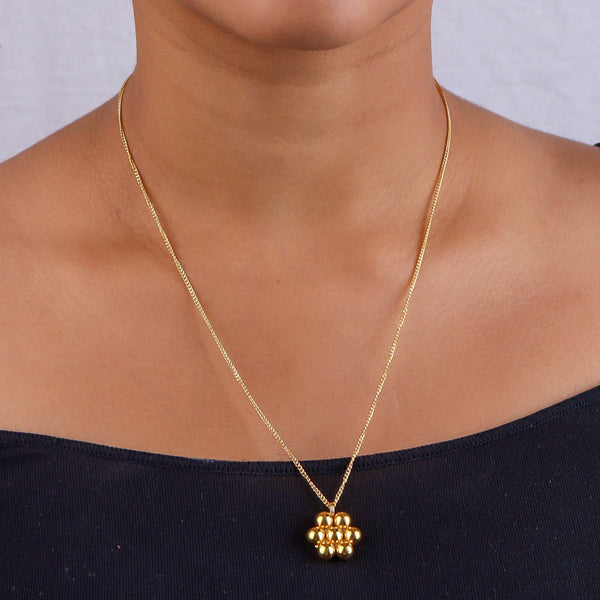 Close-up of delicate gold chain necklace on white background