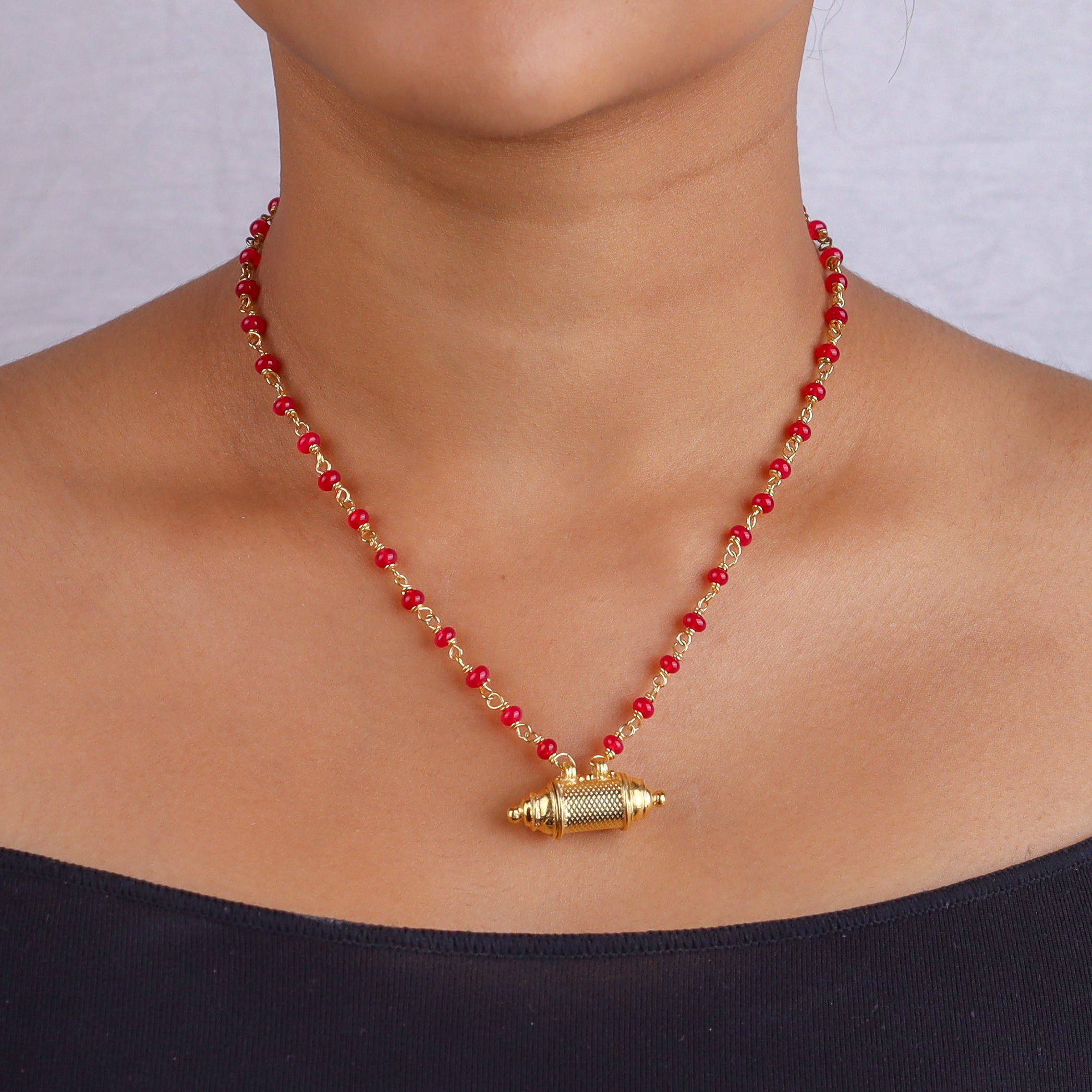 Close-up of red beaded necklace on model's neck