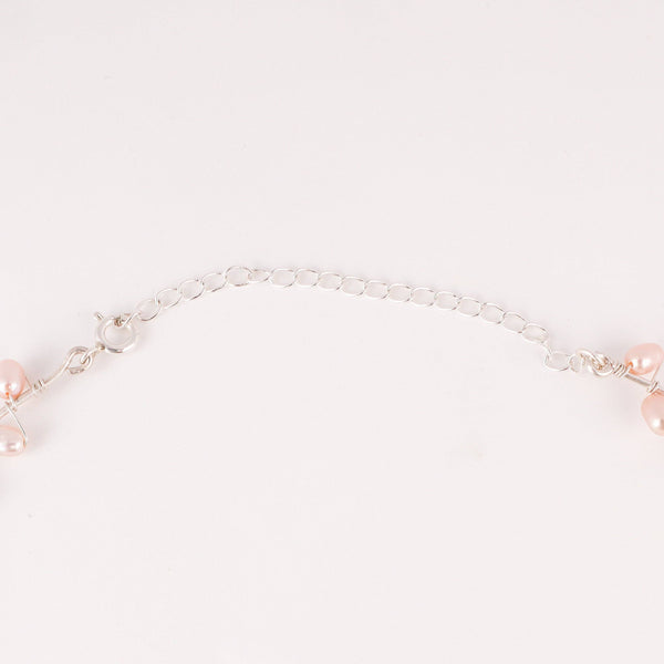 Flat-lay of fresh water pearl choker necklace on silk fabric with soft lighting