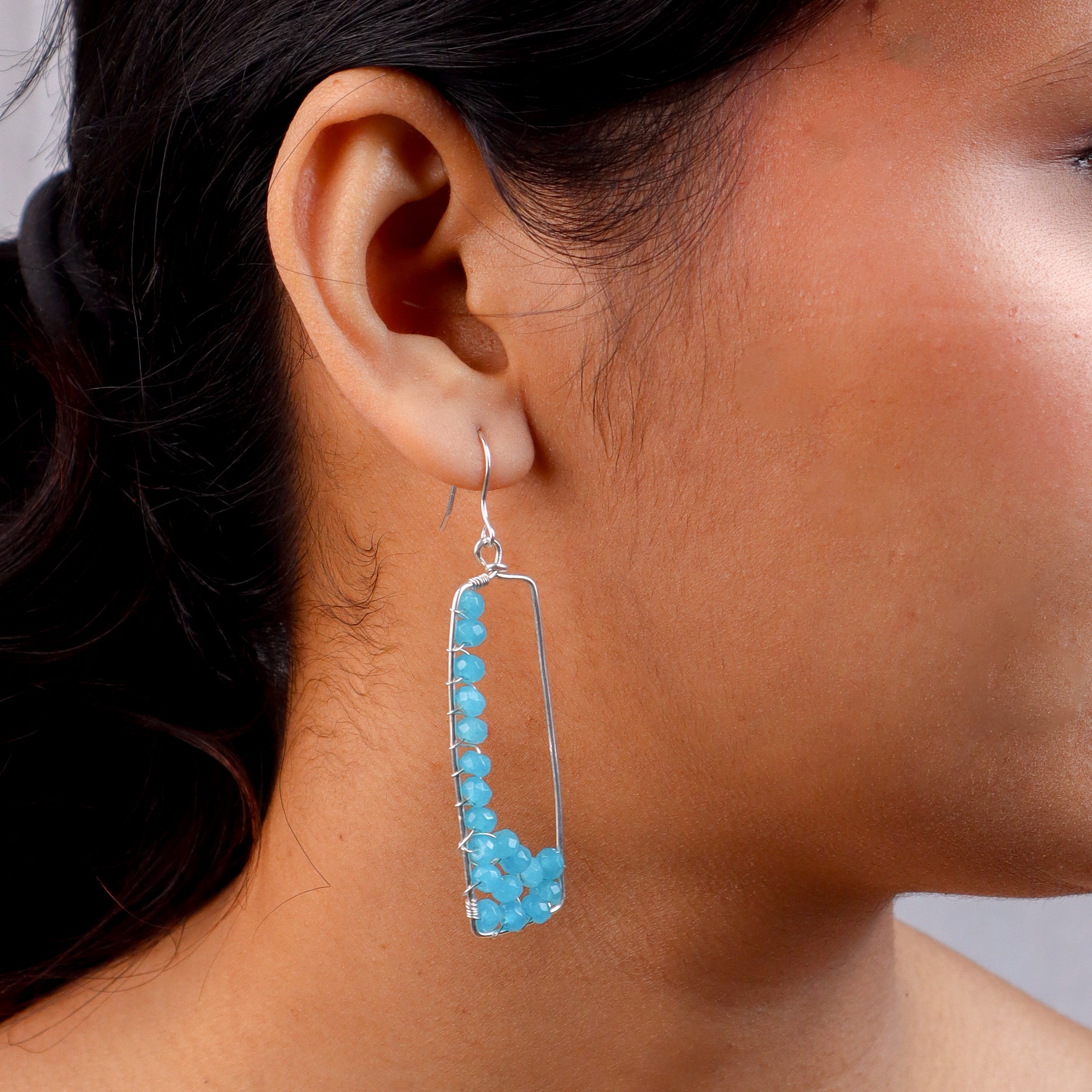 Model wearing blue arc earrings with sterling silver