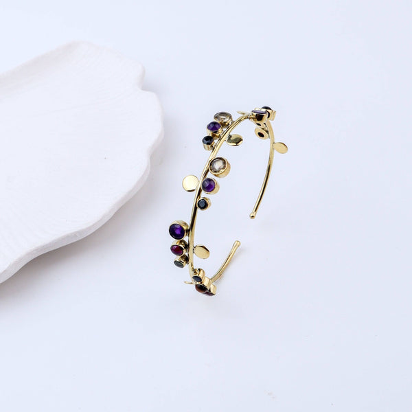 Angled view of a brass fashion bracelet highlighting its unique silhouette, structure, and polished brass finish