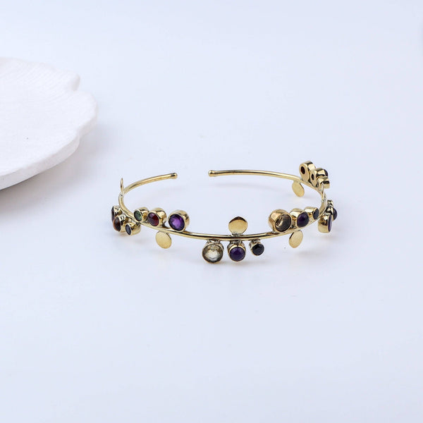 Detailed view of a brass fashion bracelet highlighting intricate motifs, textured surface, and refined brass finish