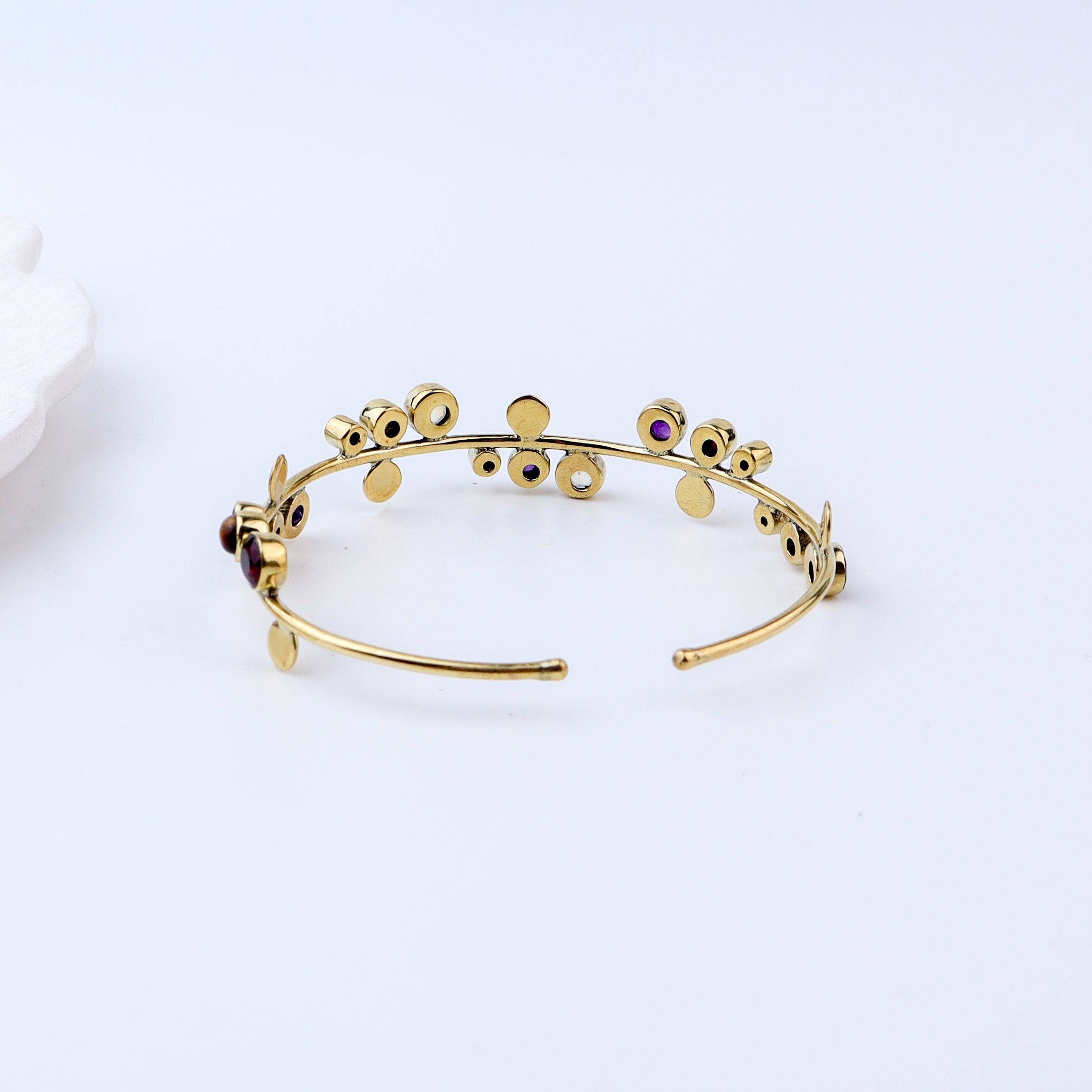 Flat-lay of a brass fashion bracelet with complementary jewellery and accessories for a chic styling setup