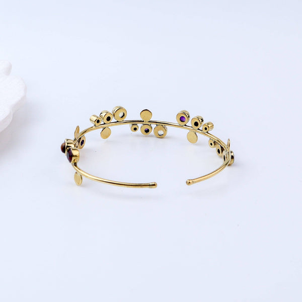 Flat-lay of a brass fashion bracelet with complementary jewellery and accessories for a chic styling setup