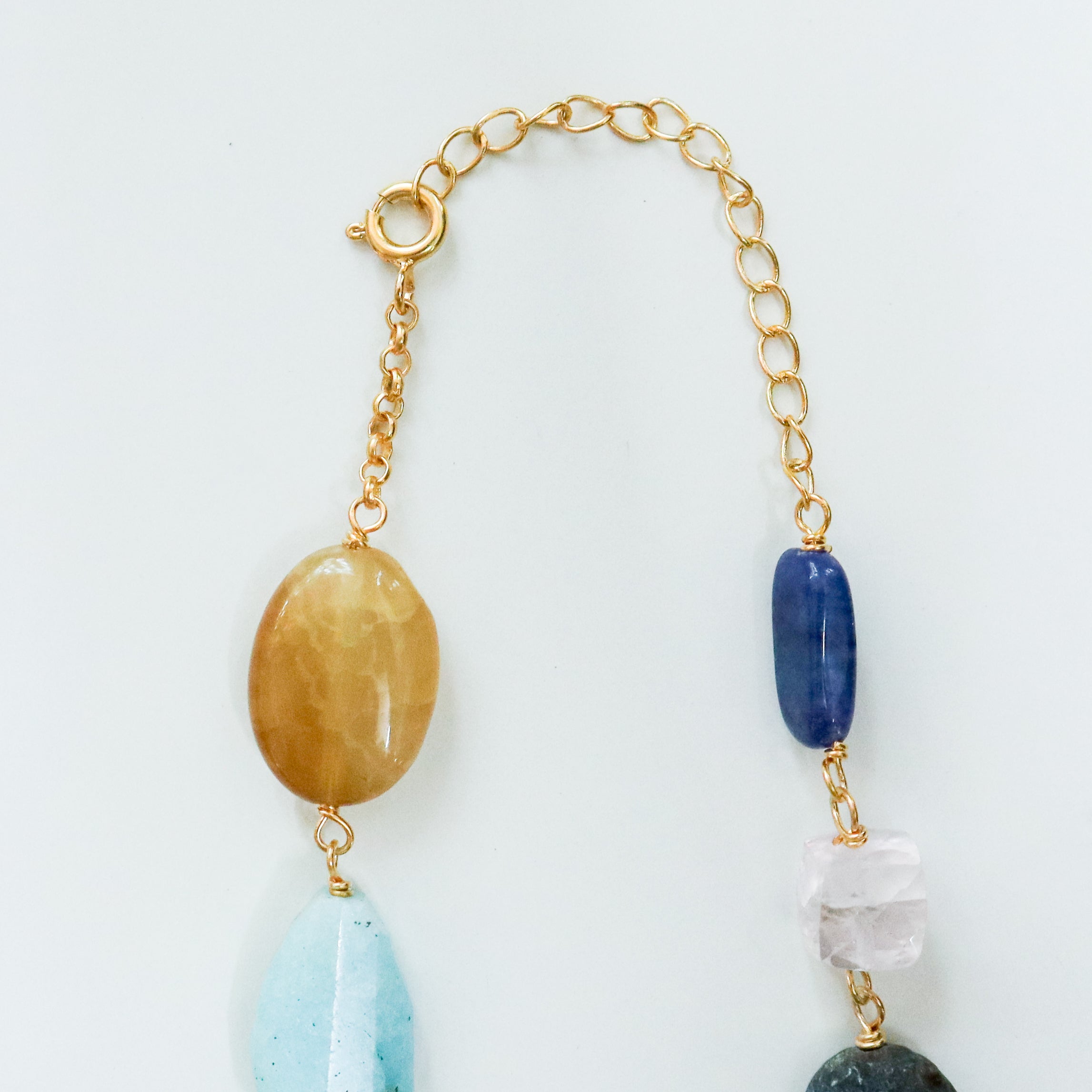 Gemstone necklace with gold chain on white background