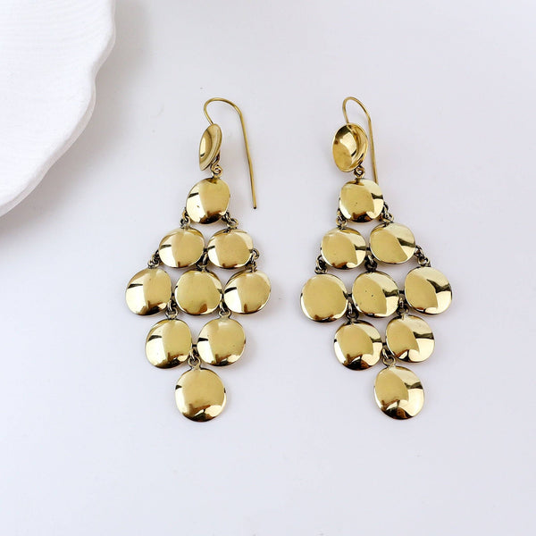Detailed view of brass fashion earrings highlighting intricate motifs, textured surface, and refined brass finish