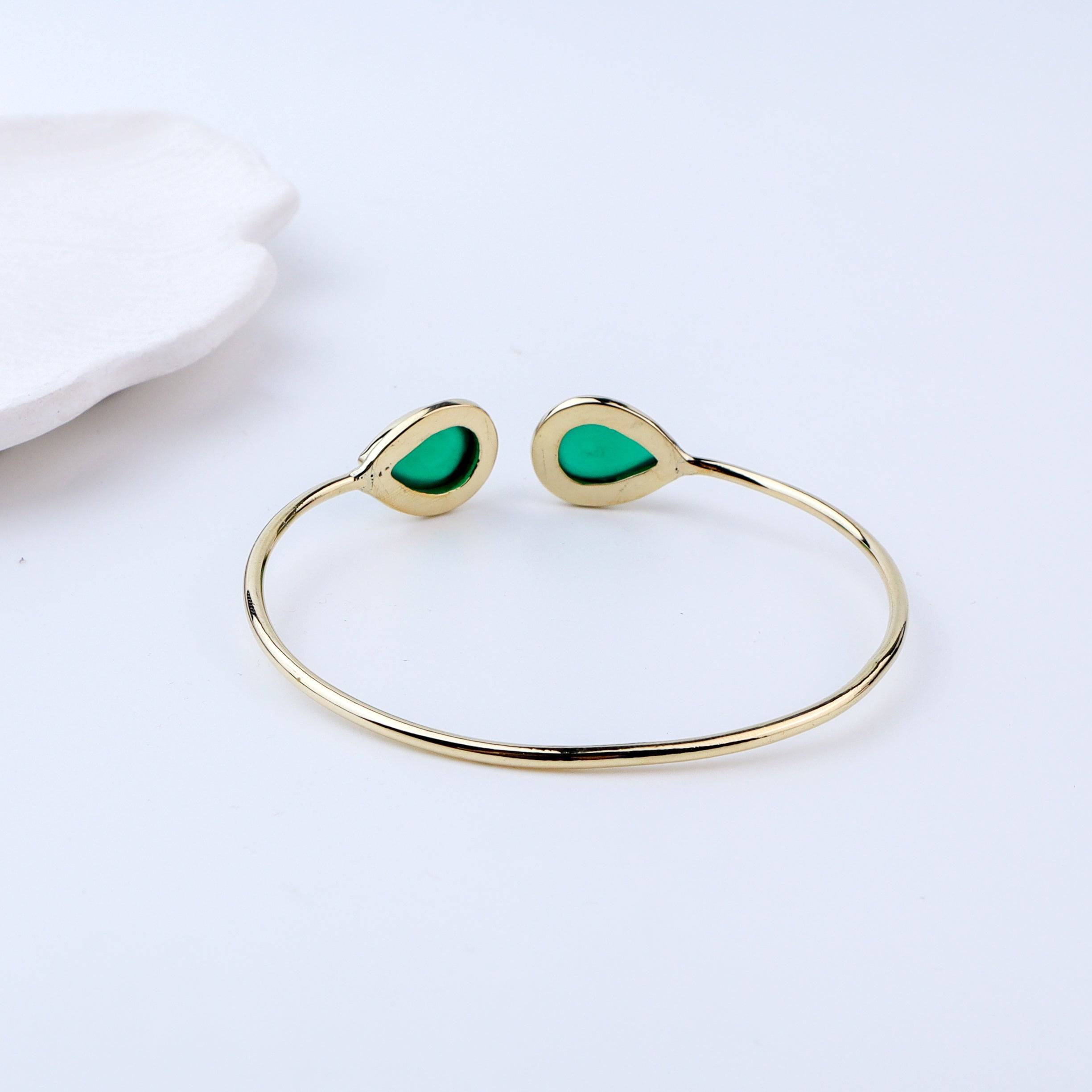 Flat-lay of a brass fashion bracelet with complementary jewellery and accessories for a chic styling setup