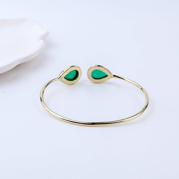 Flat-lay of a brass fashion bracelet with complementary jewellery and accessories for a chic styling setup