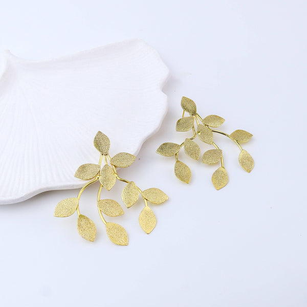 Angled view of Brass Fashion Earrings highlighting the unique silhouette, structure, and polished brass finish