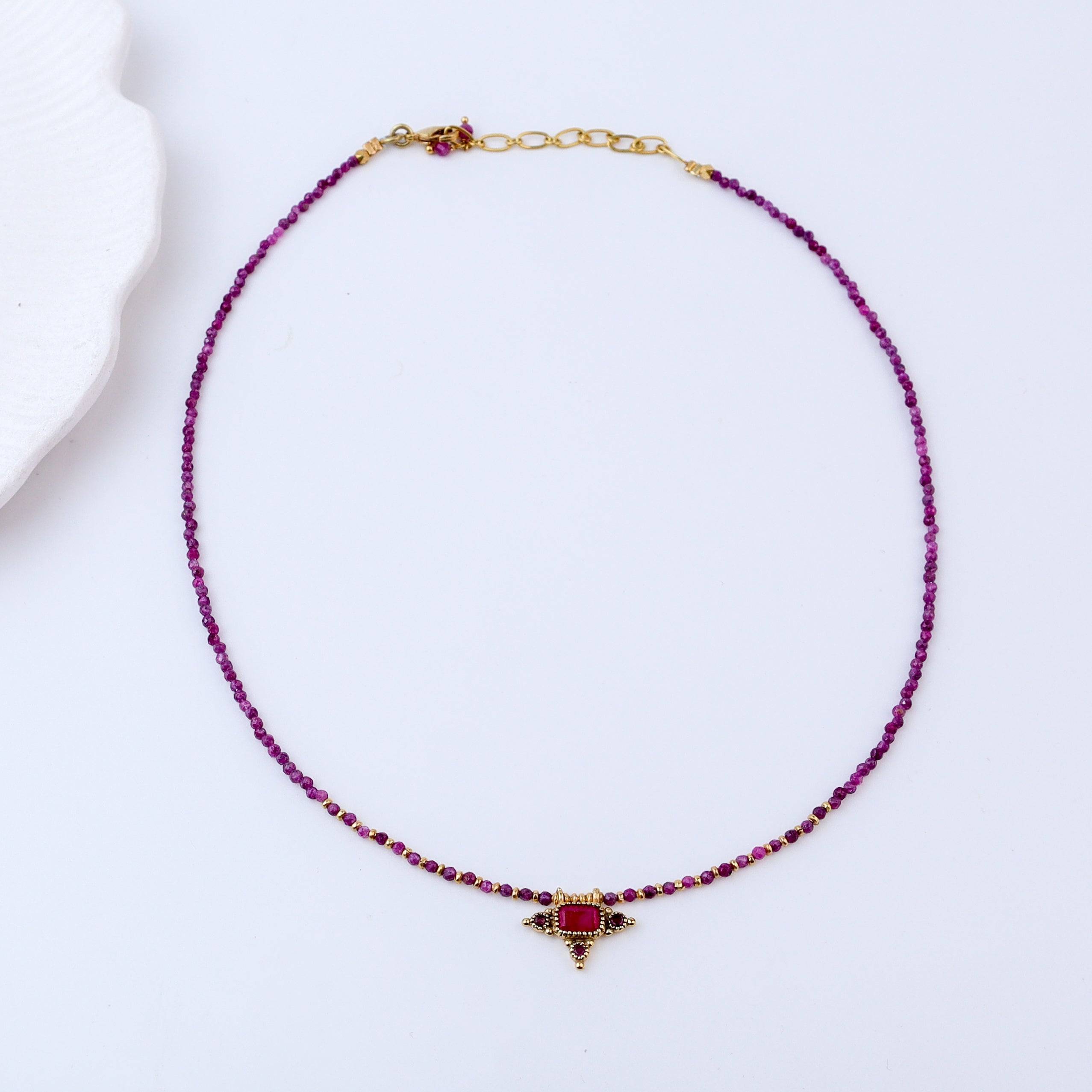 Detailed view of a brass fashion necklace highlighting intricate motifs, textured surface, and refined brass finish